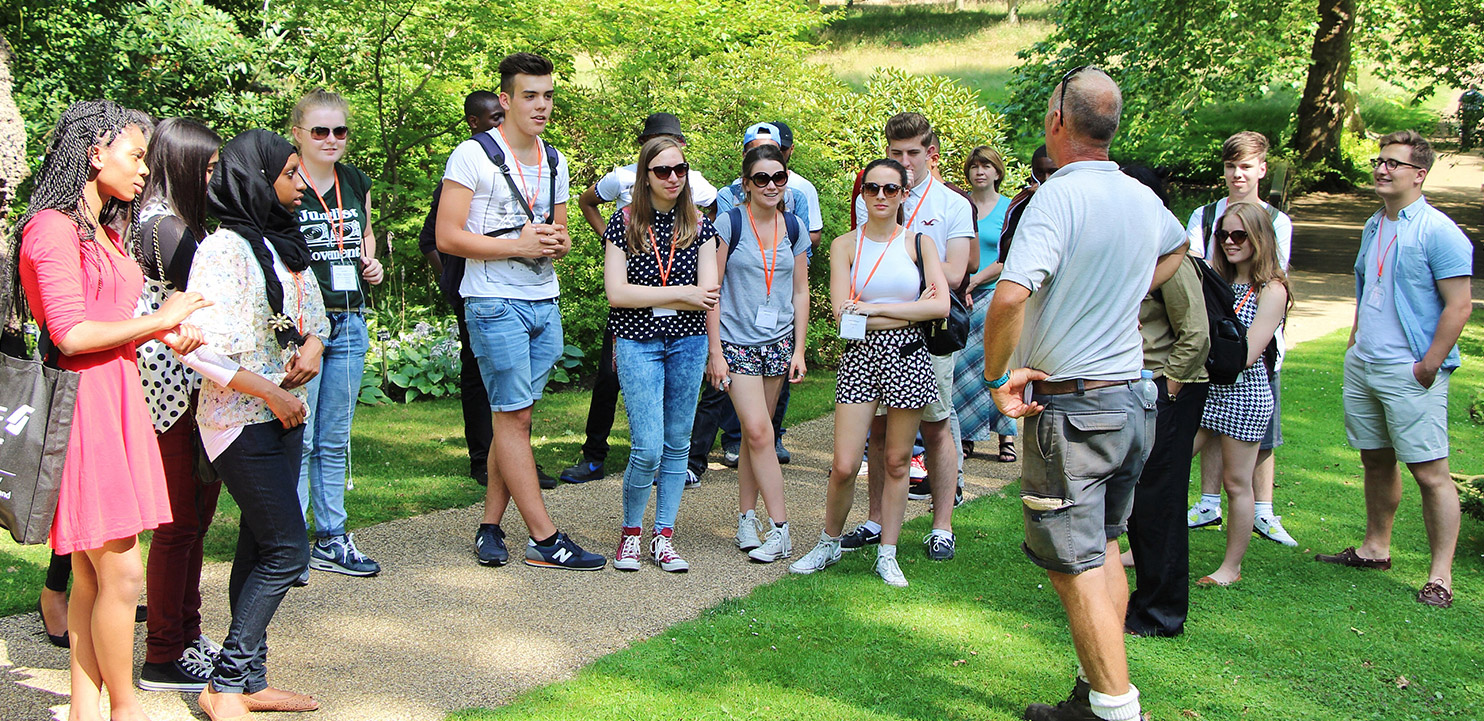 Group of young people listening to an instructor in a park