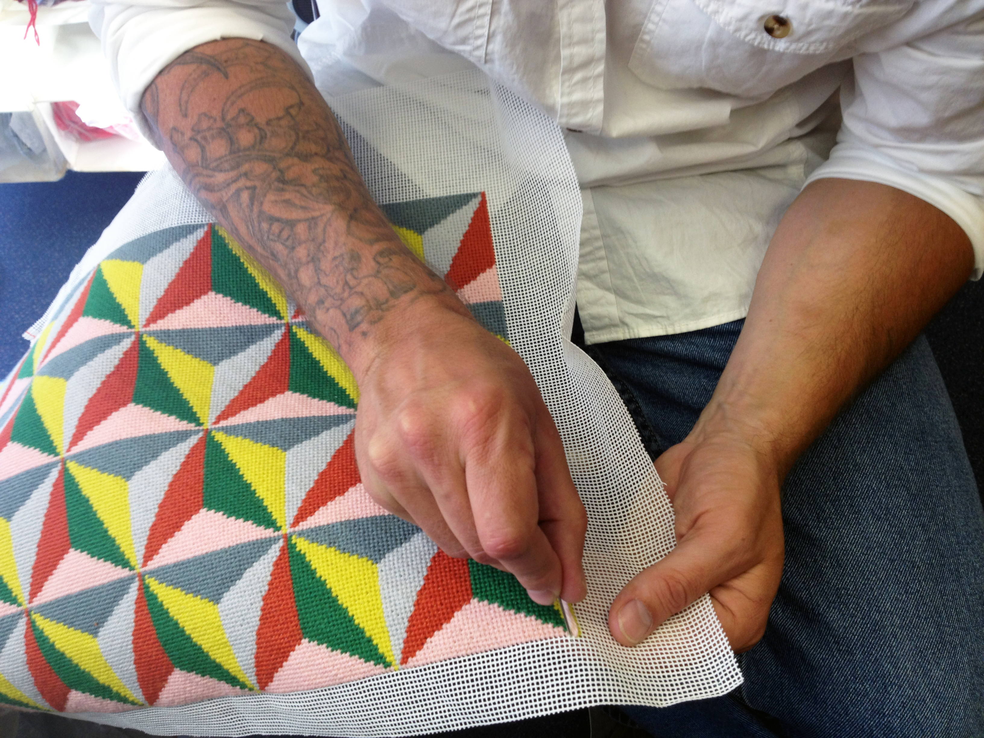 Prisoner embroidering a cushion cover from the charity Fine Cell Work